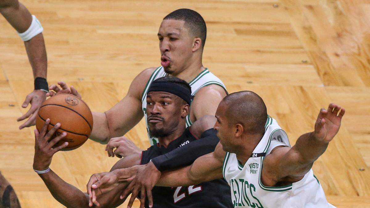 El jugador del Heat de Miami Jimmy Butler (centro) pelea por la pelota con Grant Williams y Al Horford (der.) de los Celtics, en el cuarto partido de la Final de la Conferencia Este celebrado el 23 de de mayo de 2022 en Boston.