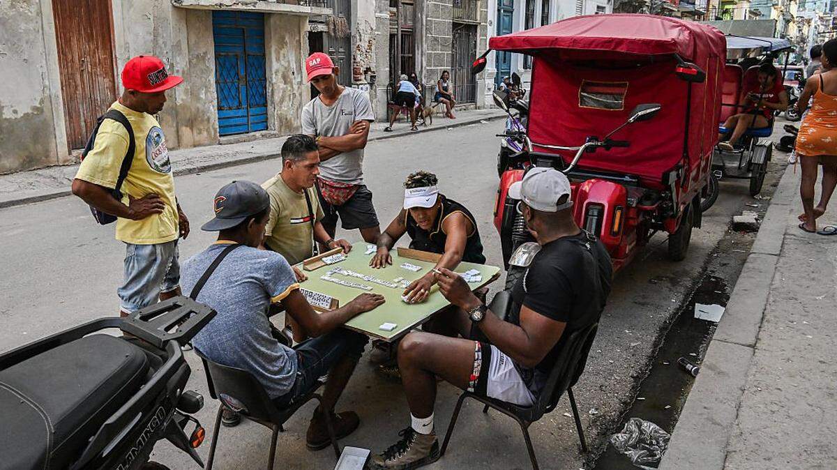 Men play dominoes in a street of Havana during a blackout on March 16, 2026. Cuba suffered a widespread power cut on March 16, 2026, according to the national electricity company, against the backdrop of a severe crisis on the island caused by the US energy blockade. (Photo by YAMIL LAGE / AFP via Getty Images)