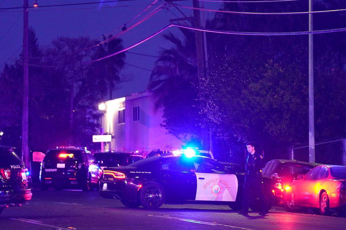 Vehículos policiales de varias agencias bloquean una calle cerca de la escena de un tiroteo en Sacramento, California, el lunes 28 de febrero de 2022.