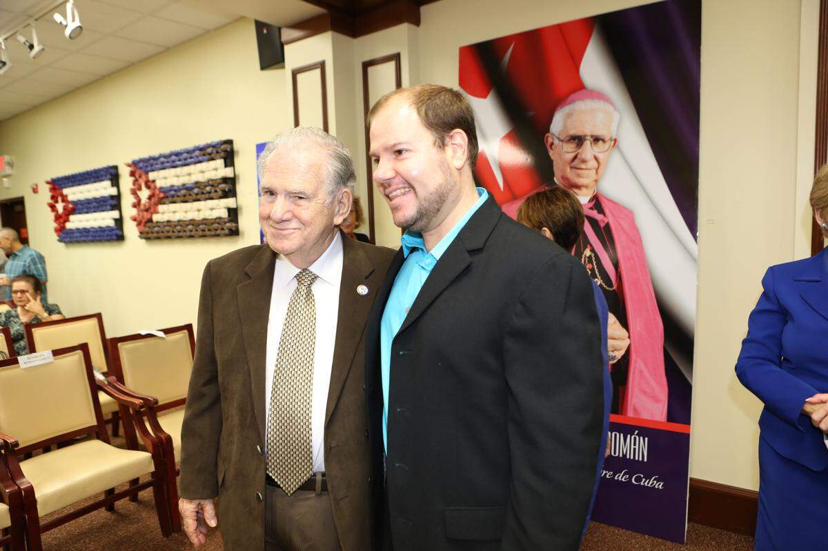 El reverendo Martín N. Añorga junto al editor de El Nuevo Herald, Daniel Shoer Roth, durante la presentación del proyecto de la biografía de Monseñor Román en 2013. Añorga, quien compartió una profunda amistad con Monseñor Román, trabajó a su lado en grupos ecuménicos, promoviendo la unidad entre comunidades religiosas en Miami.