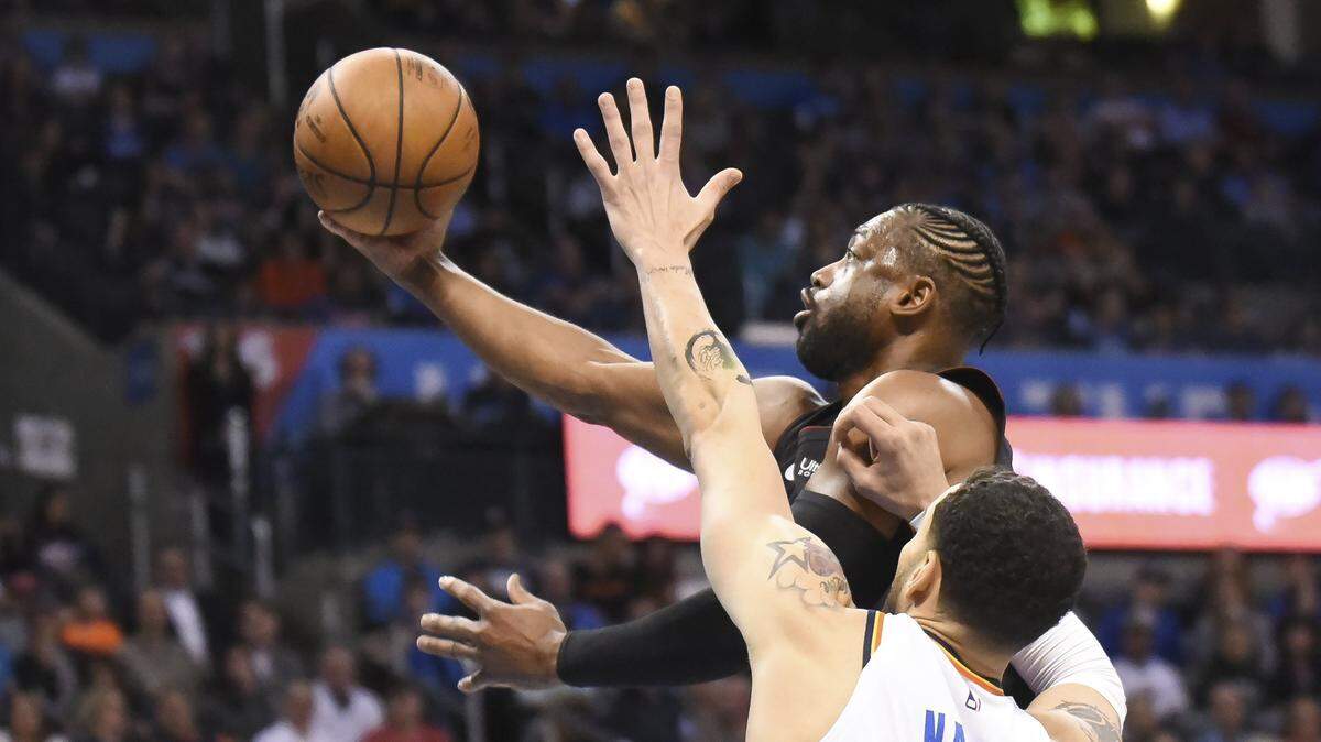 El escolta del Heat Dwyane Wade entra al aro ante la marca de Abdul Nader, del Thunder, en el partido celebrado el 18 de marzo de 2019 en Oklahoma.