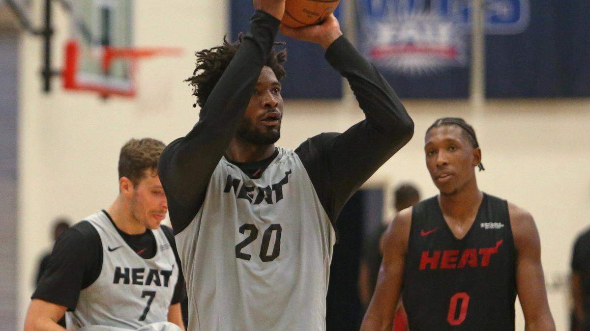 Justise Winslow tira al aro, mientras sus compañeros del Heat Goran Dragic (izq.) y Josh Richardson (der.) esperan su turno, en el entrenamiento de este viernes en FAU.