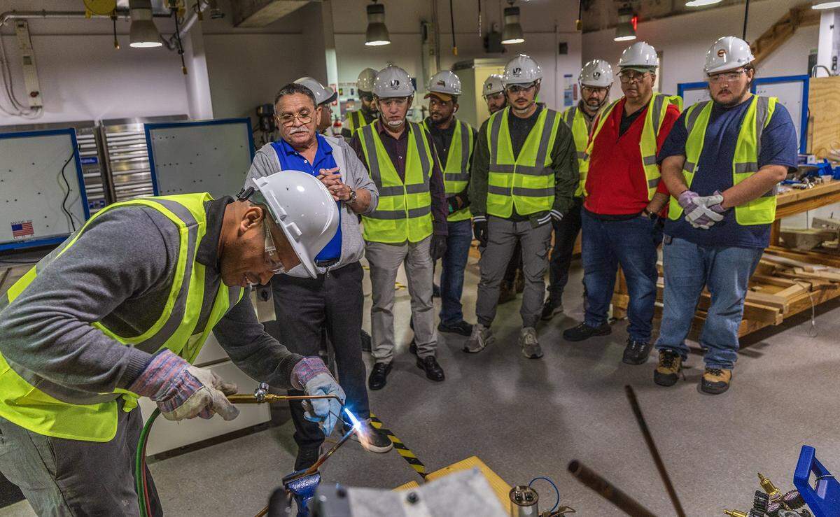 Students looks on as Instructor Omar Silva supervises as student Reinier Colas demonstrates soldering an ac unit coil copper lines, during a nHVAC/R Technician Certificate Program class, at Miami Dade College North Campus, in North Miami, on Thursday, February 05, 2026.
