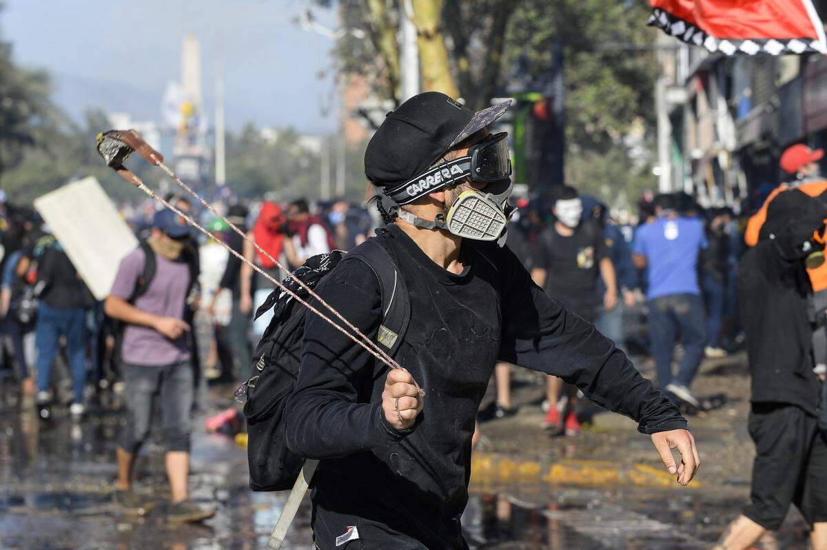 Un manifestante se enfrenta a los policías antimotines durante una protesta el martes, 26 de noviembre de 2019, en Santiago de Chile.