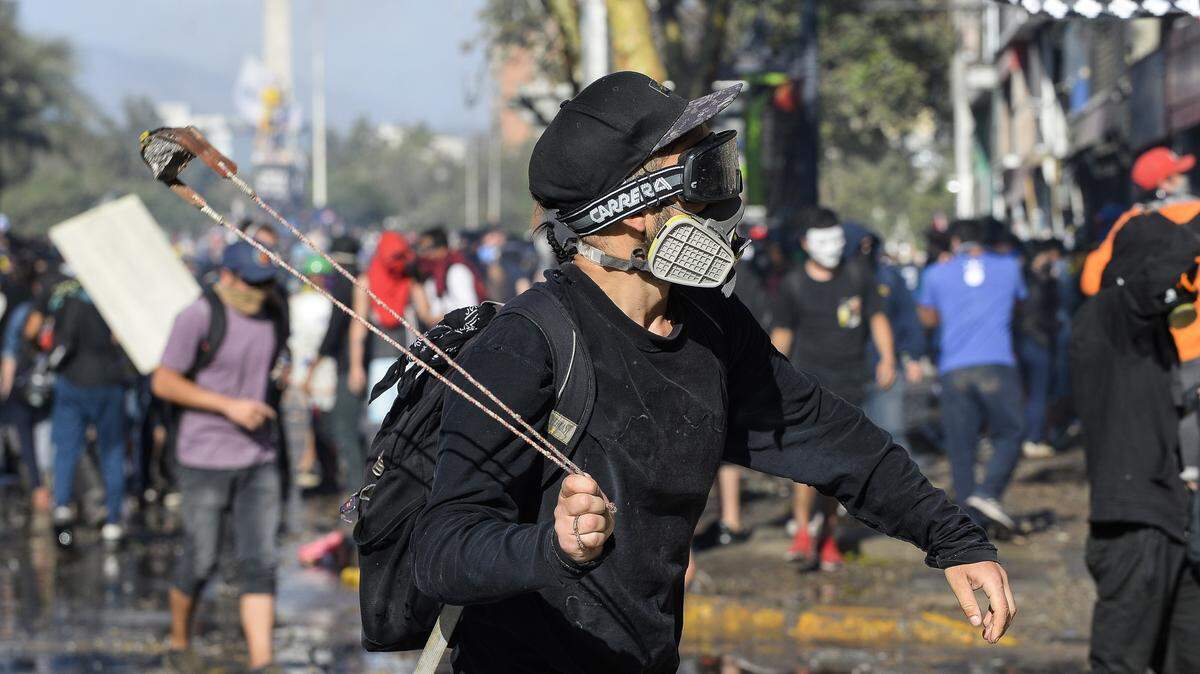 Un manifestante se enfrenta a los policías antimotines durante una protesta el martes, 26 de noviembre de 2019, en Santiago de Chile.