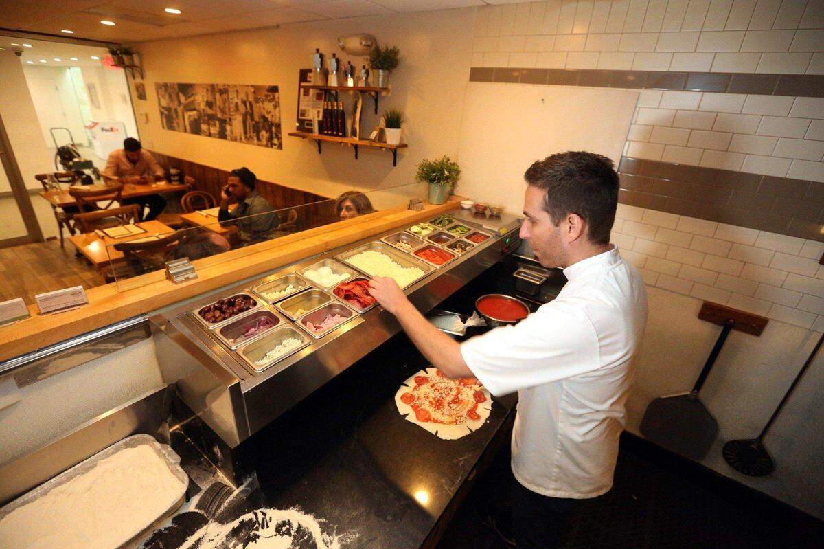 El chef Renato Viola trabaja en la creación de una pizza Star Luca, una de las favoritas del local de Miami Beach.