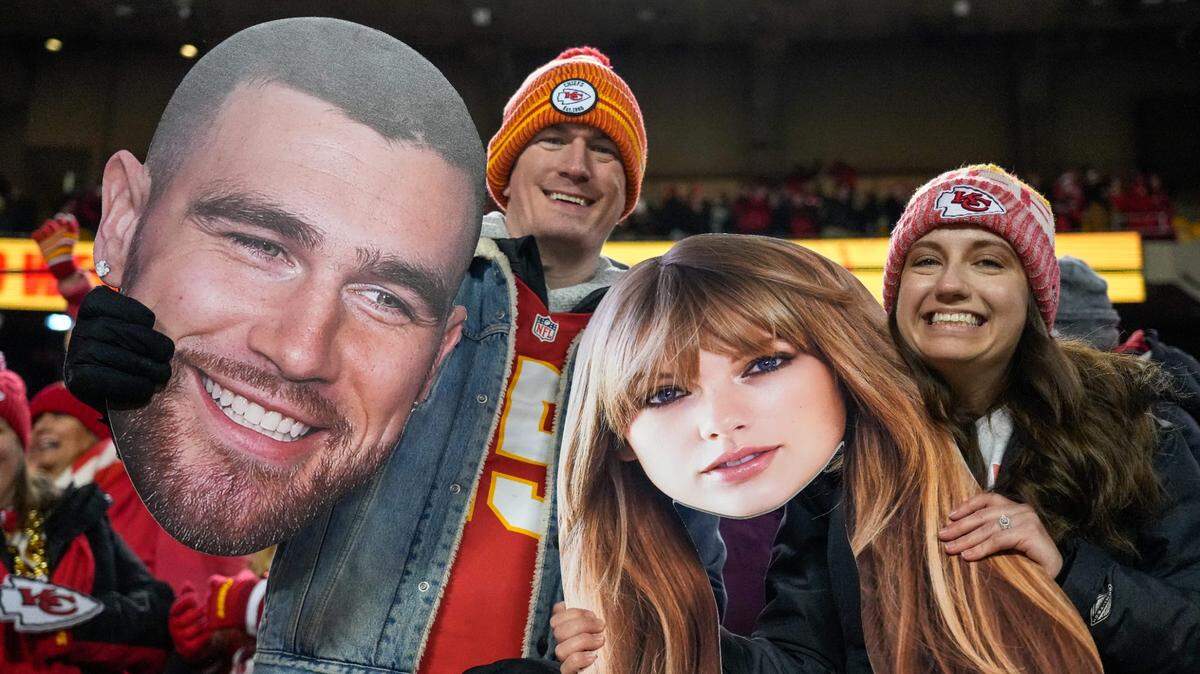 Dos fanáticos posan con dos fotos grandes de Travis Kelce y Taylor Swift en el partido de la NFL entre los Chiefs y los Bengals de Cincinnati, celebrado el 31 de diciembre de 2023 en Kansas City.