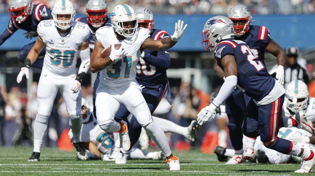 El running back de los Dolphins de Miami Raheem Mostert (31) corre con el ovoide ante la marca del safety de los Patriots Jaylinn Hawkins, en el partido de la NFL celebrado el 6 de octubre de 2024 en el Gillette Stadium en Foxborough, Massachusetts.