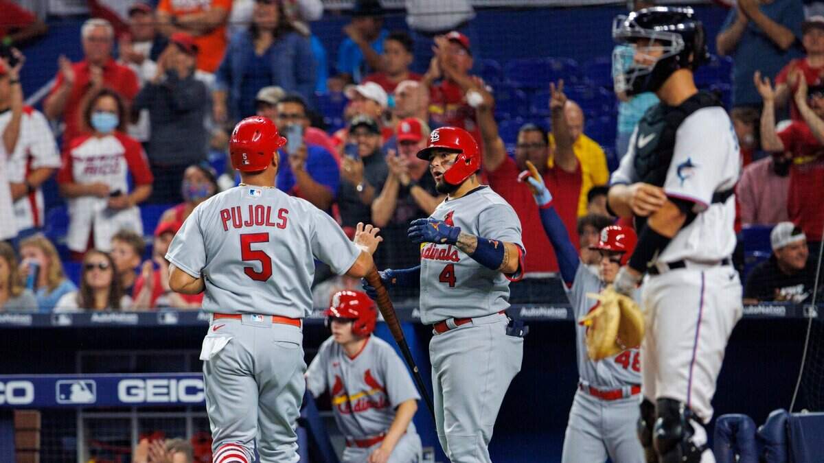 Albert Pujols (izq.) es felicitado por Yadier Molina tras anotar una carrera para los Cardenales de San Luis en el segundo inning del partido ante los Marlins, el 19 de abril de 2022 en Miami.