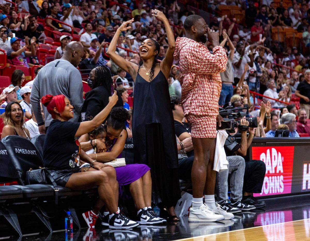 La exestrella del Heat Dwyane Wade y su esposa Gabrielle Union alientan a Udonis Haslem en el primer cuarto del partido ante el Magic de Orlando, celebrado el 9 de abril de 2023 en Miami.