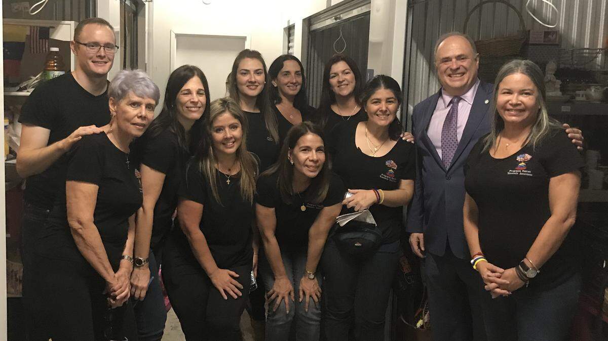 The mayor of the City of Doral, Juan Carlos Bermudez, poses for a photo with the team of volunteers from Raíces Venezolanas, a local charity that supports newly arrived Venezuelan immigrants.