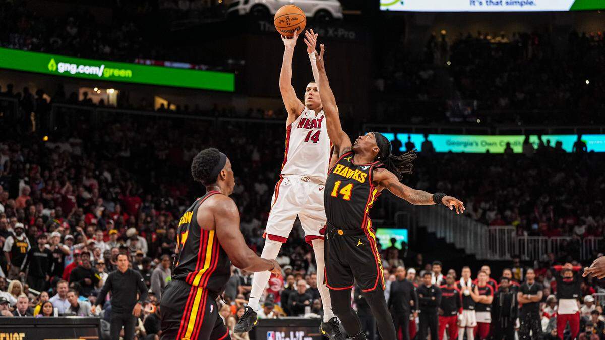 El escolta del Heat, Tyler Herro (14), dispara ante el defensa de los Hawks, Terance Mann (14), durante la segunda mitad en el State Farm Arena el 8 de abril de 2025 en Atlanta, Georgia.