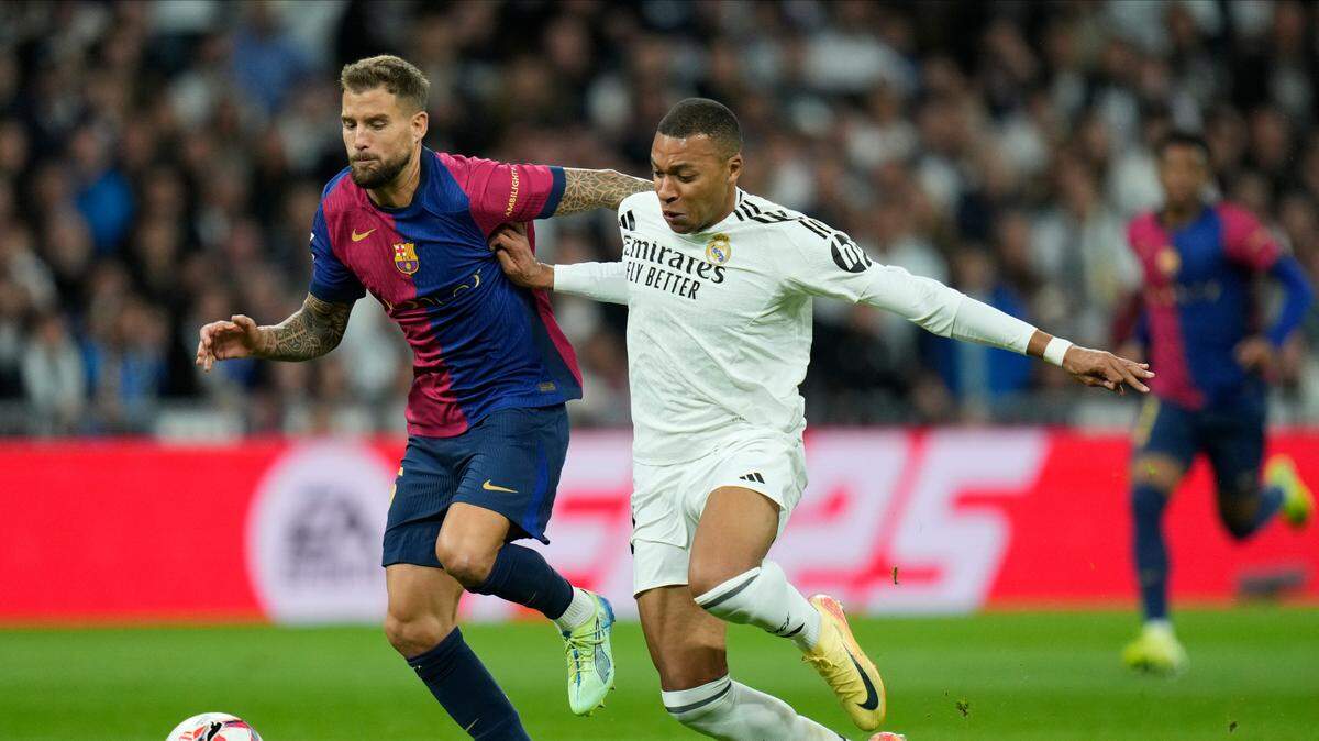 Foto de archivo. El delantero del Real Madrid Kylian Mbappé (der.) lucha la pelota con el defensa de Barcelona Iñigo Martínez, en el partido de la liga española celebrado el 26 de octubre de 2024 en Madrid.