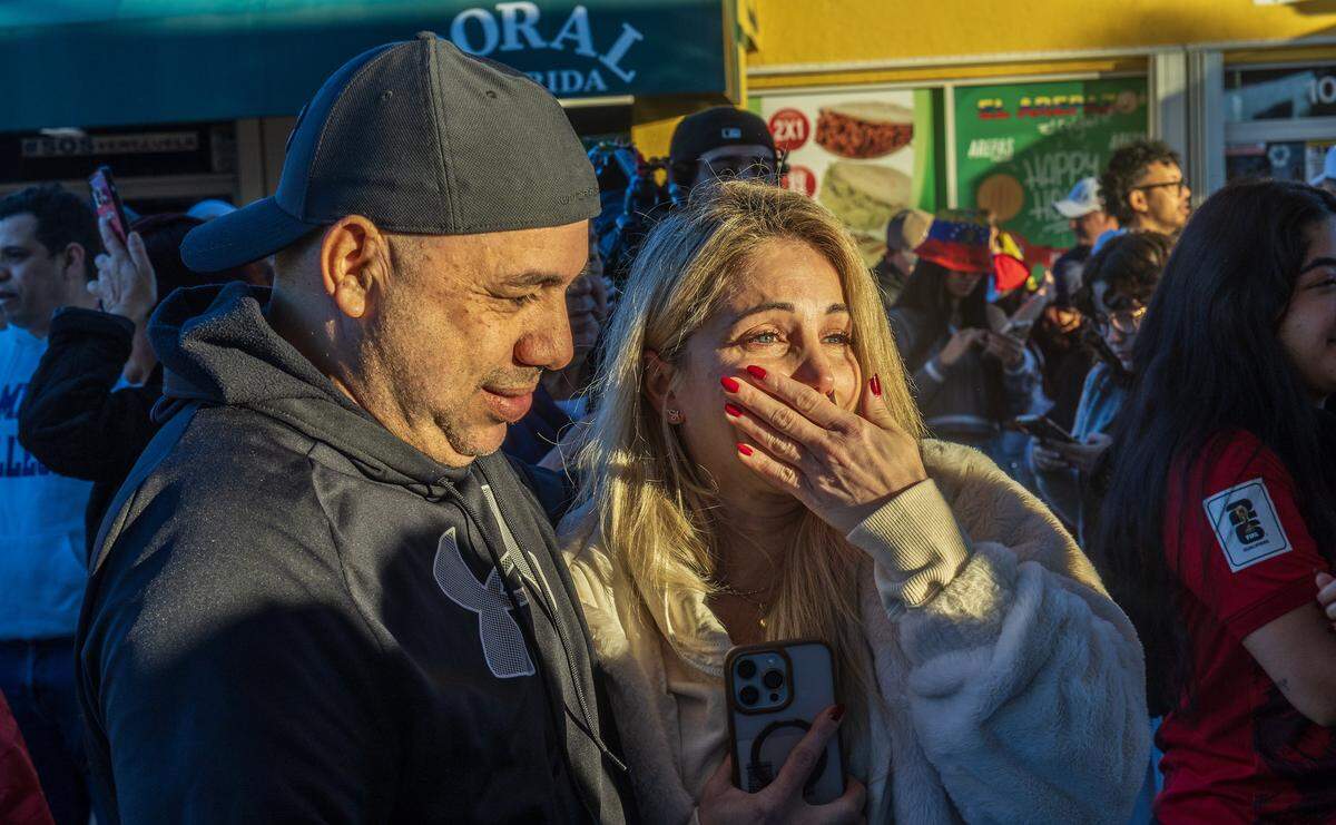 Esther Zalchendler y Giovanni Gamboa reaccionan mientras se unían a un grupo de venezolanos exiliados que viven en el sur de Florida celebrando frente a El Arepazo, en Doral, Florida, después de que Estados Unidos atacara Venezuela y capturara al líder venezolano Nicolás Maduro, el 3 de enero de 2026.