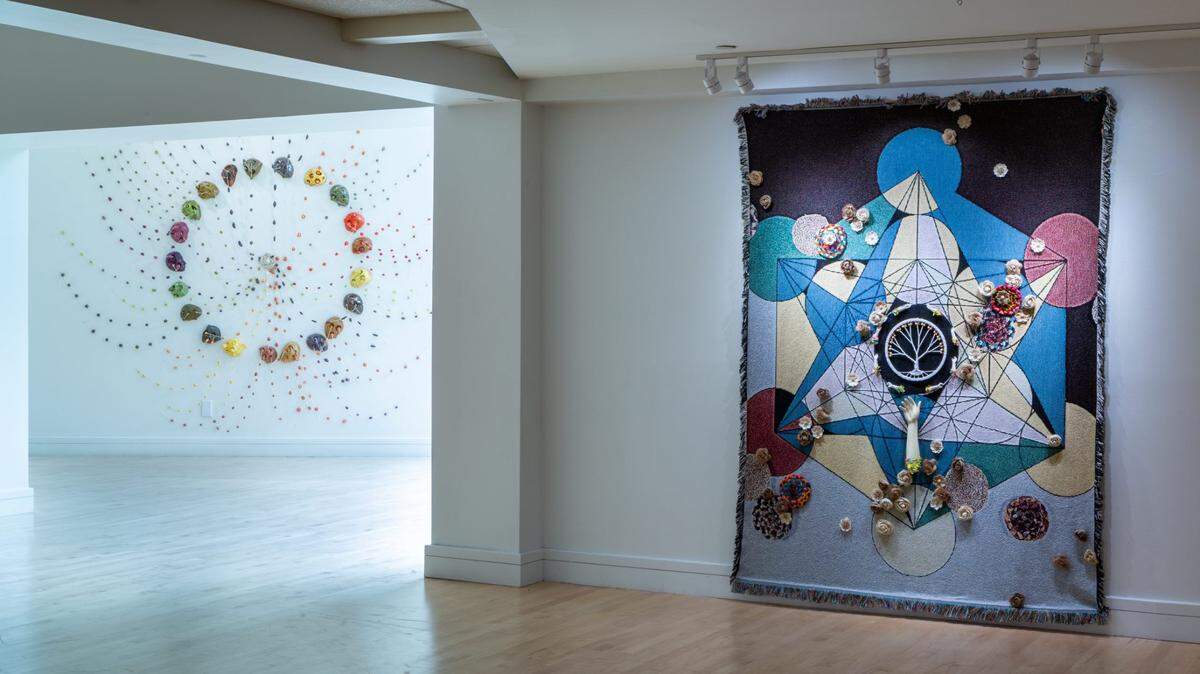 Panorámica de exhibición ‘Ancestral Lines’ en el Coral Springs Museum of Art. Izquierda: ‘Réquiem’, 2024, de Milena Martínez Pedrosa. Textil y cerámica, 96 pulgadas de diámetro. Derecha: ‘The Ancestral Tree’, 2024, de Ivone Ferrer. Medios mixtos, 82 x 64 pulgadas.