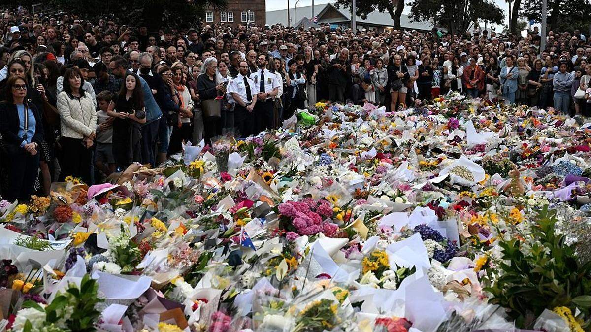 Mourners gather at a tribute at the Bondi Pavilion in memory of the victims of a shooting at Bondi Beach, in Sydney on December 16, 2025. Australia's leaders have agreed to toughen gun laws after attackers killed 15 people at a Jewish festival on Bondi Beach, the worst mass shooting in decades decried as antisemitic "terrorism" by authorities. (Photo by Saeed KHAN / AFP via Getty Images)