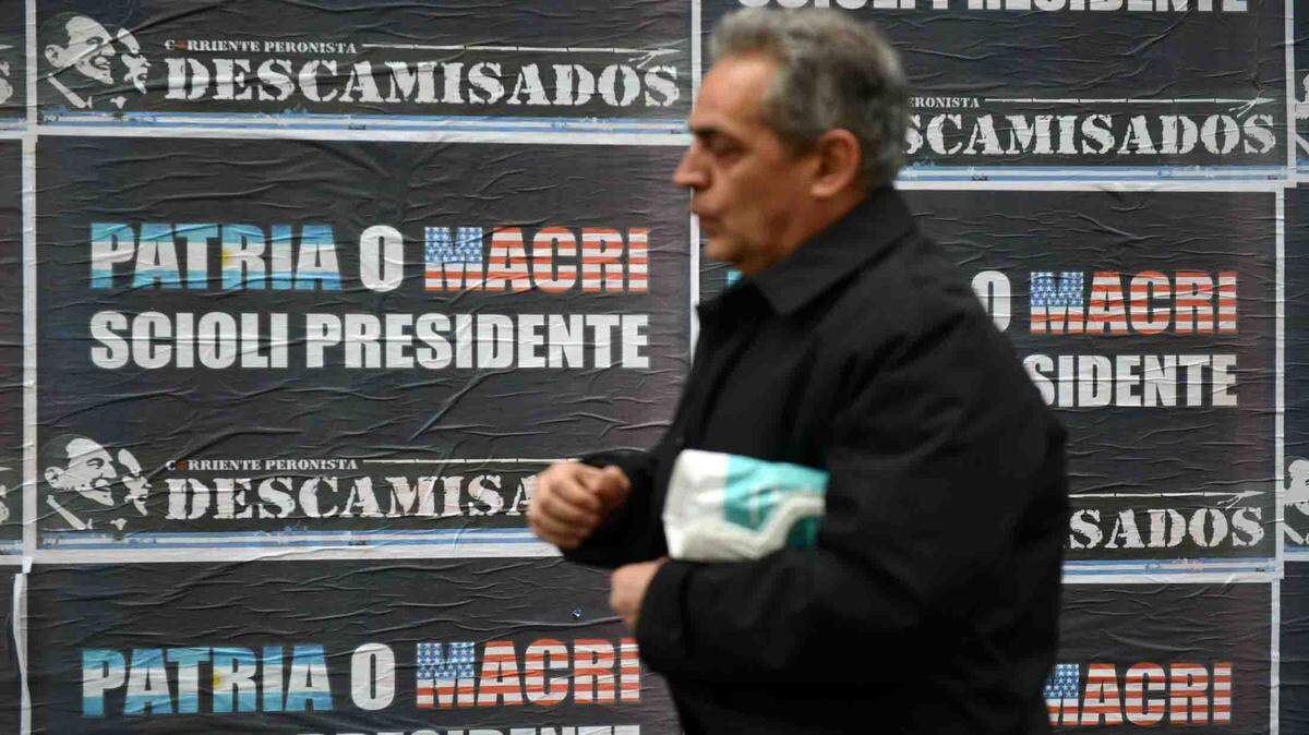 Un hombre camina frente a la propaganda política del candidato oficialista Daniel Scioli contra Mauricio Macri, el 30 de octubre en Buenos Aires, Argentina. 