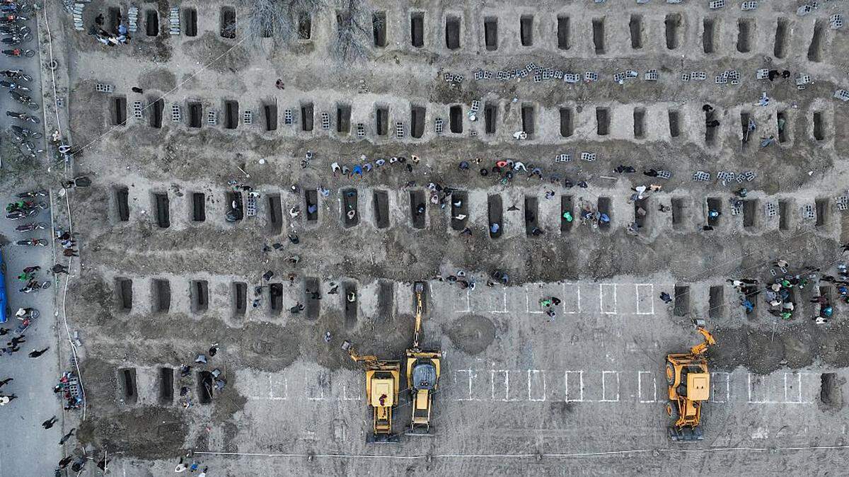 En esta fotografía aérea difundida por el Centro de Prensa de Irán, los dolientes cavan tumbas durante el funeral de los niños muertos en un supuesto ataque a una escuela primaria en la provincia iraní de Hormozgan, en Minab, el 3 de marzo de 2026.