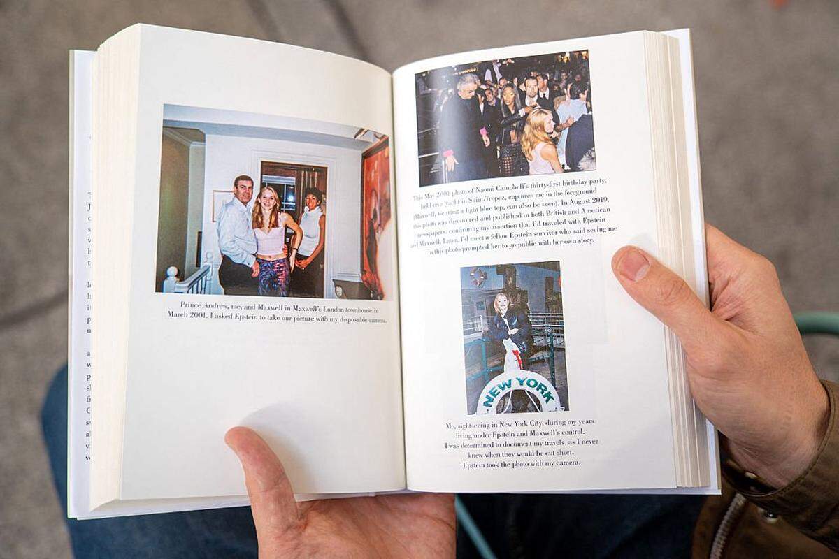 A person holds open pages of the book "Nobody's Girl - A Memoir of Surviving Abuse and Fighting for Justice" by Virginia Roberts Giuffre, displaying photos published in the book, as it is pictured in central London on October 21, 2025, on the day of its release in the UK. A memoir by one of Jeffrey Epstein's main accusers whose claims led to the downfall of Britain's Prince Andrew was released Tuesday, promising to keep Epstein's ties to President Donald Trump in the spotlight. (Photo by Niklas HALLE'N / AFP) (Photo by NIKLAS HALLE'N/AFP via Getty Images)