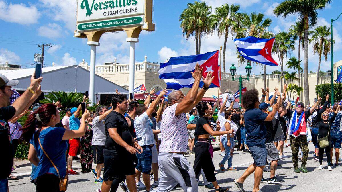 People march in the streets and wave Cuban flags during a protest in solidarity with thousands of Cubans who took to the streets in various locations in Cuba, in one of the largest protests to take place on the island, at Versailles Cuban Restaurant off 8th Street in the Little Havana neighborhood of Miami, Florida, on Sunday, July 11, 2021.