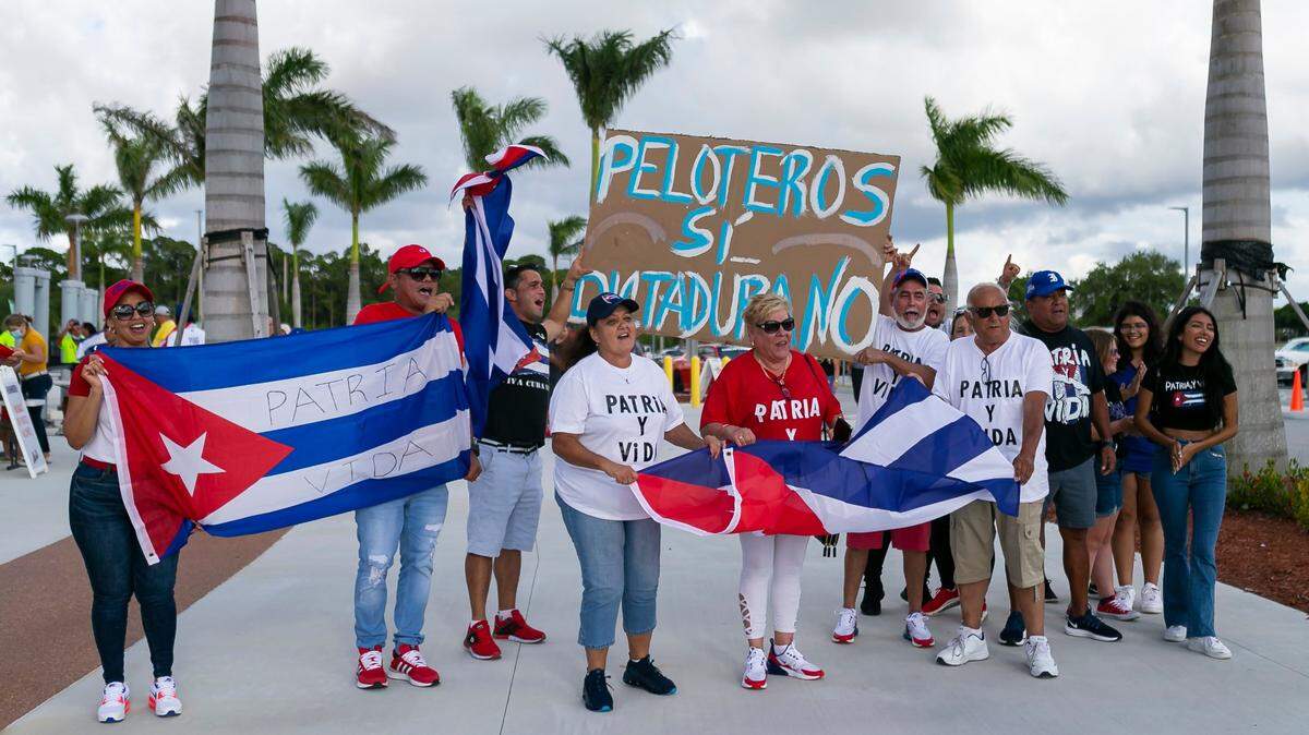 Un grupo de personas se manifiestan contra el régimen cubano antes del partido entre la selección antillana y Canadá en el Preolímpico de béisbol en el Clover Park en Port St. Lucie, Florida, el 1ro de junio de 2021.