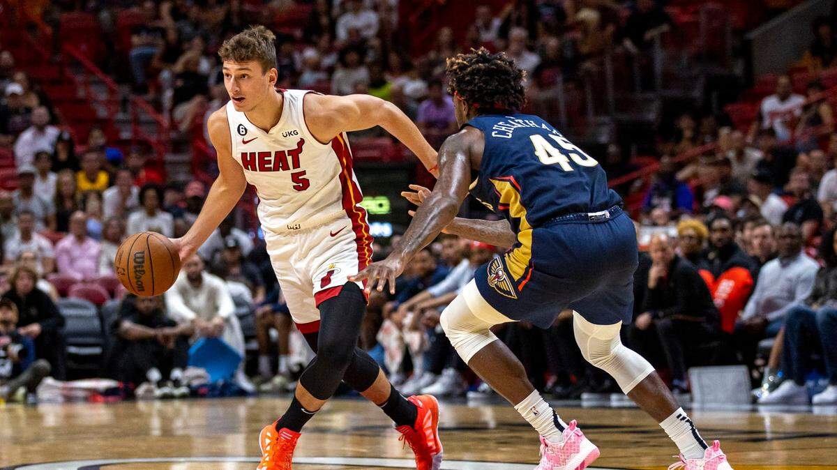 El jugador del Heat Nikola Jovic (5) conduce la pelota ante la marca de Zylan Cheatham, de los Pelicans de New Orleans, celebrado el 12 de octubre de 2022 en Miami.