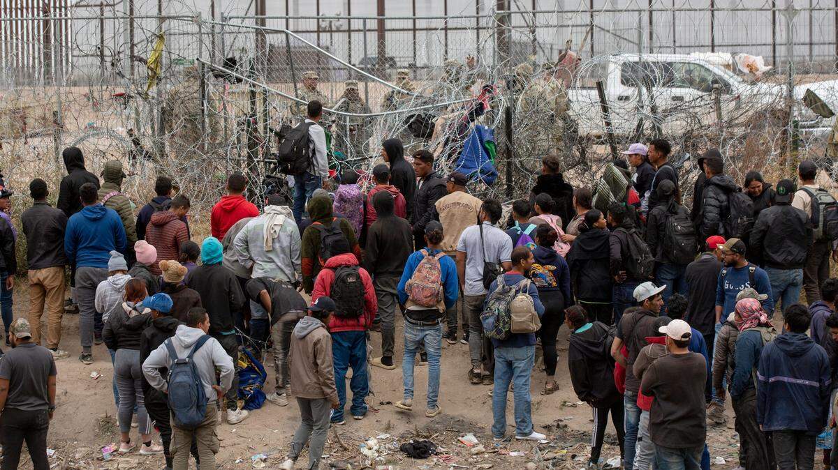 Foto de archivo. Decenas de inmigrantes le piden a agentes de la Guardia Nacional de Texas que les permitan pasar al lado norte del Río Grande, en El Paso, Texas, para ser procesados por la Patrulla Fronteriza de Estados Unidos, el 20 de marzo de 2024.