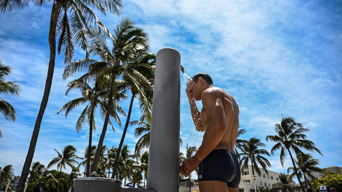 Un hombre se ducha en plena tarde calurosa en Miami Beach, Florida, el 22 de julio de 2025.