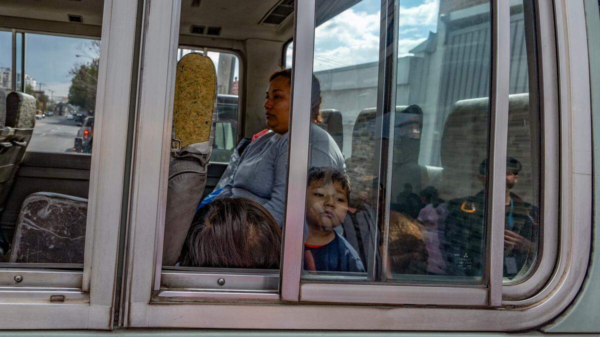 Migrantes guatemaltecos con niños son llevados a un refugio para migrantes después de llegar en un vuelo de deportación desde Estados Unidos, el 19 de febrero de 2025.