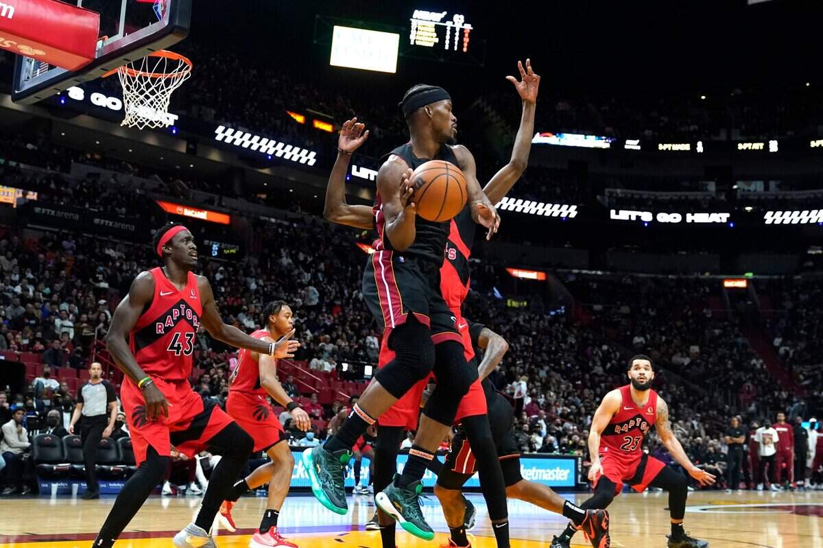 El jugador del Heat Jimmy Butler trata de pasar la pelota ante la marca de la defensa de los Raptors, en el partido celebrado el 1ro de febrero de 2022 en Toronto.