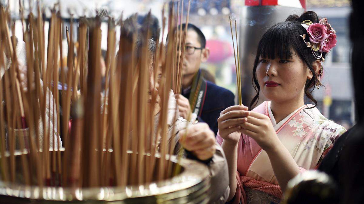 Una mujer vestida con un kimono enciende palos de incienso cerca de Tokio. Los modelos predictivos apuntan que en poco más de 15 años los bosques de Boswellia se reducirán un 50%, según la publicación científica Nature Sustainability.