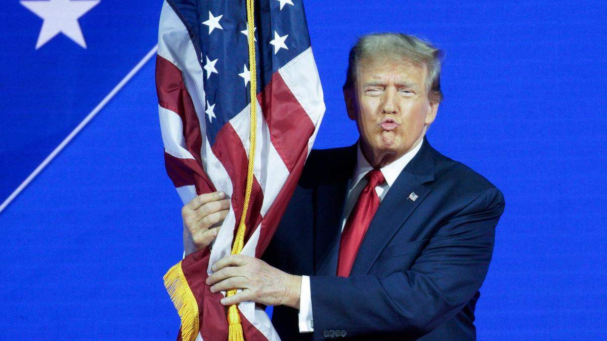 El expresidente Donald Trump abrazo una bandera de Estados Unidos antes de dar un discurso en la conferencia conservadora CPAC, en National Harbor, Maryland, el sábado 24 de febrero de 2024.