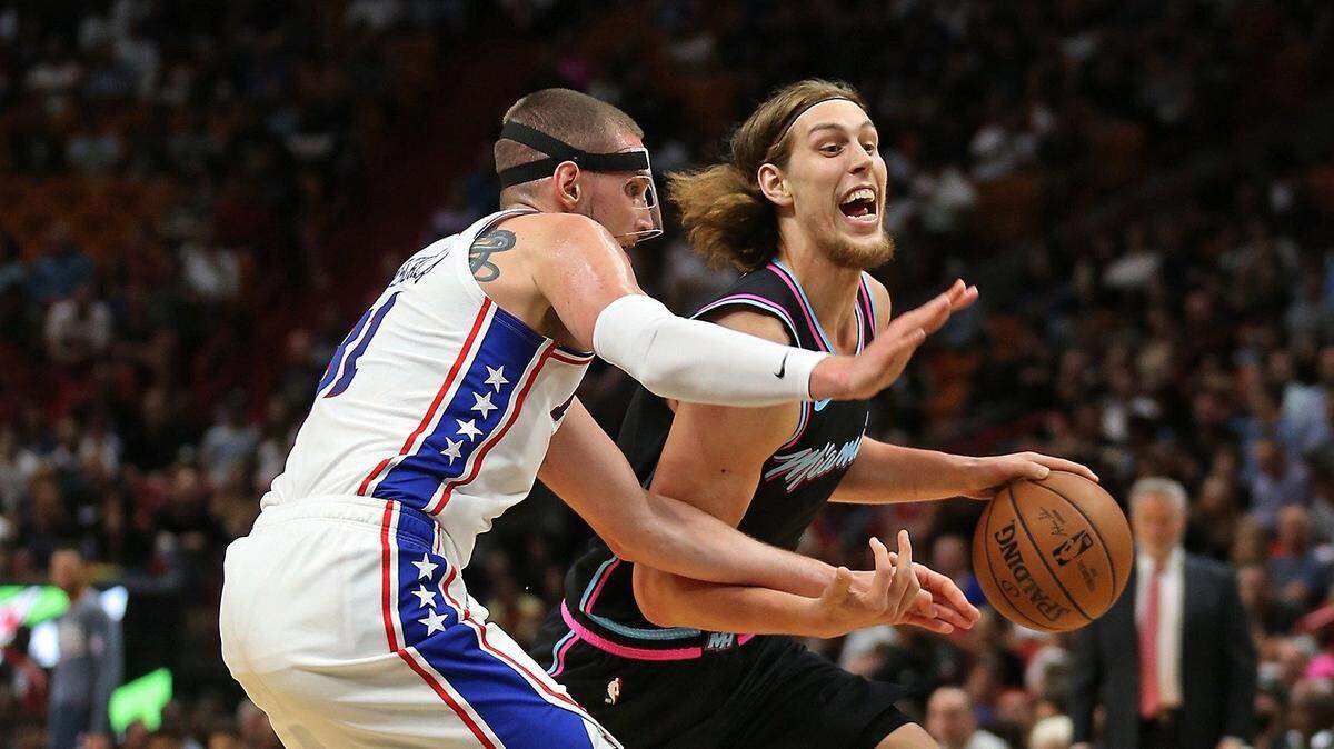 El jugador del Heat Kelly Olynyk (der.) conduce la pelota ante la defensa de Mike Muscala, de Filadelfia, en el partido efectuado el 12 de noviembre de 2018 en Miami.