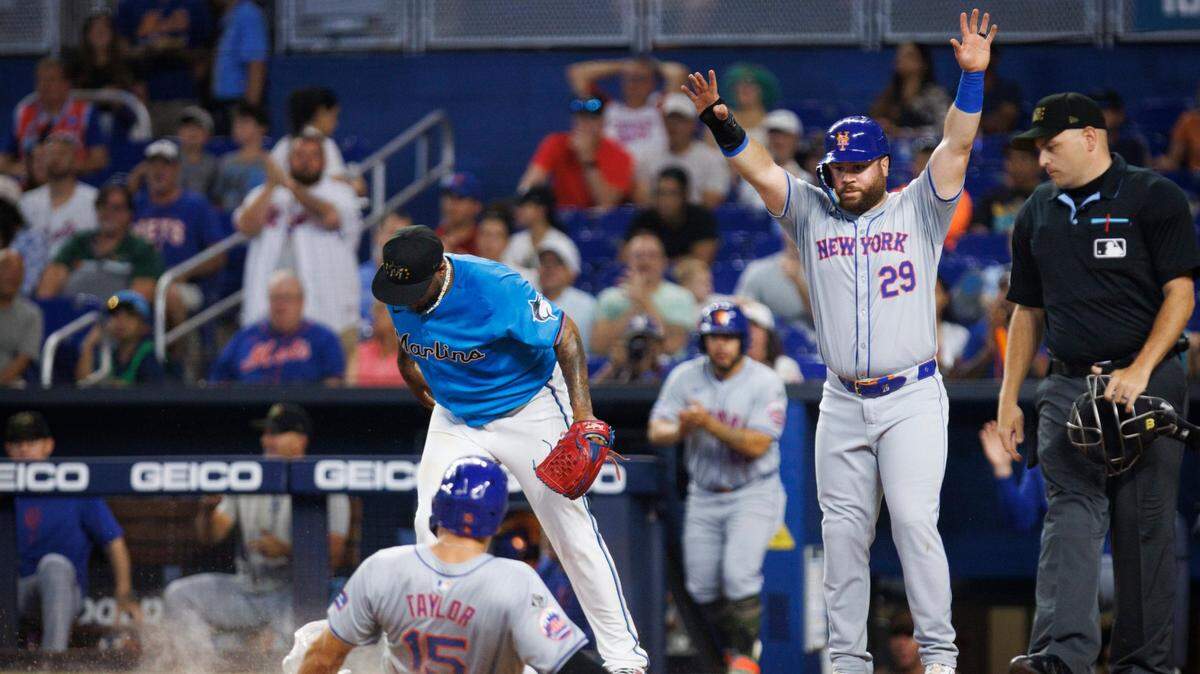 El jardinero de los Mets de Nueva York Tyrone Taylor se desliza en el plato durante la primera entrada del partido ante los Marlins, celebrado el 19 de mayo de 2024 en Miami.