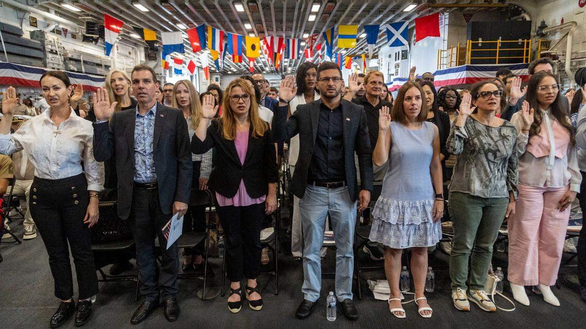 New U.S. citizens take the oath during a naturalization ceremony hosted by U.S. Citizenship and Immigration Services aboard the USS Bataan in Miami.