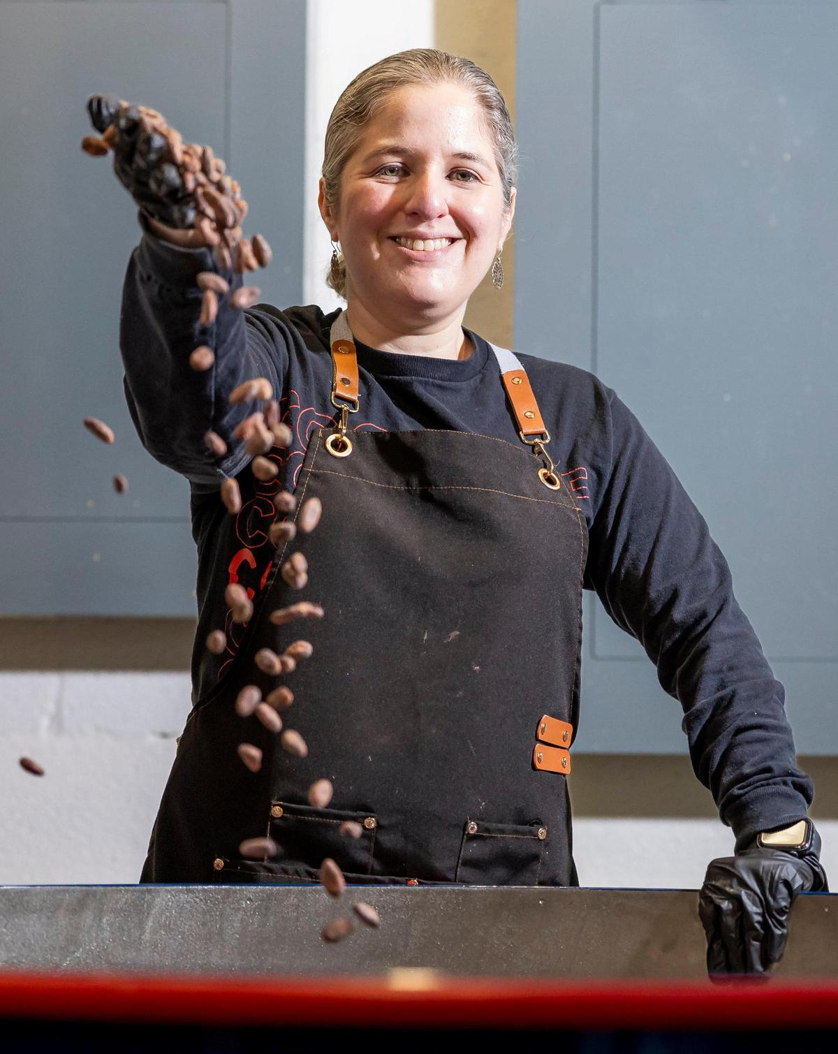Carolina Quijano muestra los granos de cacao de su tostadora de café reutilizada en la nueva fábrica de Exquisito Chocolate en Miami.