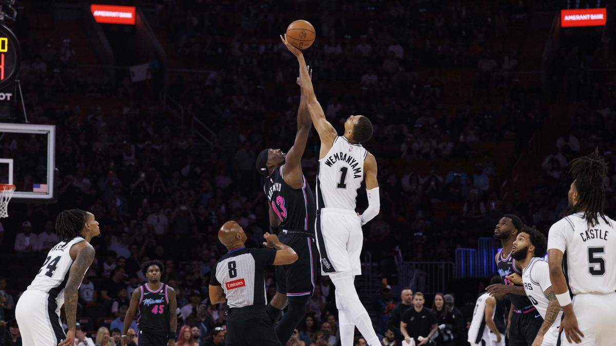 El centro del Heat Bam Adebayo (izq.) y el astro de los Spurs de San Antonio Victor Wembanyama saltan en el inicio de la primera mitad del partido celebrado el 23 de marzo de 2026 en el Kaseya Center, en Miami, Florida.
