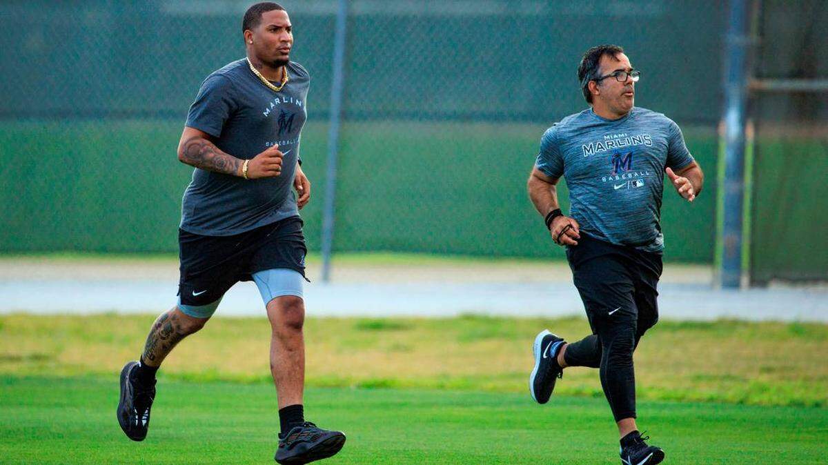 El lanzador de los Marlins, Sixto Sánchez, corre con el coordinador de fuerza y ​​acondicionamiento de rehabilitación del equipo, Alexander Pons, durante el entrenamiento de primavera en el Roger Dean Stadium, el 15 de marzo de 2022 en Jupiter, Florida.