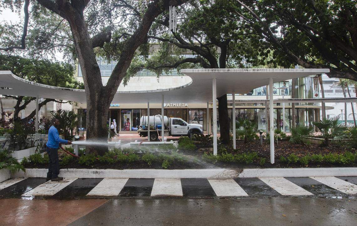 Un empleado de Miami Beach limpia un bordillo en el Lincoln Road Mall, donde una renovación, largamente postergada y actualmente en curso, restaurará y renovará el paisajismo, los elementos de agua y las estructuras de sombra como la que se ve aquí.