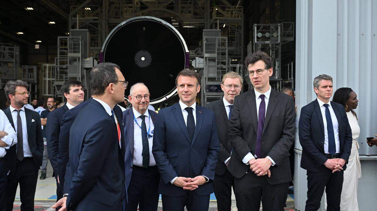 El presidente de Francia, Emmanuel Macron (centro), junto a varios jefes empresariales, visita la planta de ensamblaje de los cohetes Ariane 6 de la empresa Arianespace, en la Guyana Francesa, el 26 de marzo de 2024.