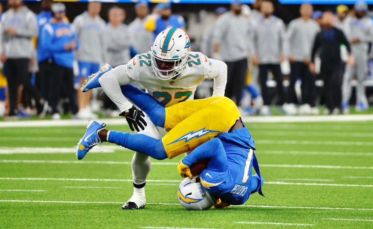 El cornerback de los Dolphins de Miami Elijah Campbell derriba al wide receiver de los Chargers DeAndre Carter, en el partido celebrado el 11 de diciembre de 2022 en el SoFi Stadium en Inglewood, California.