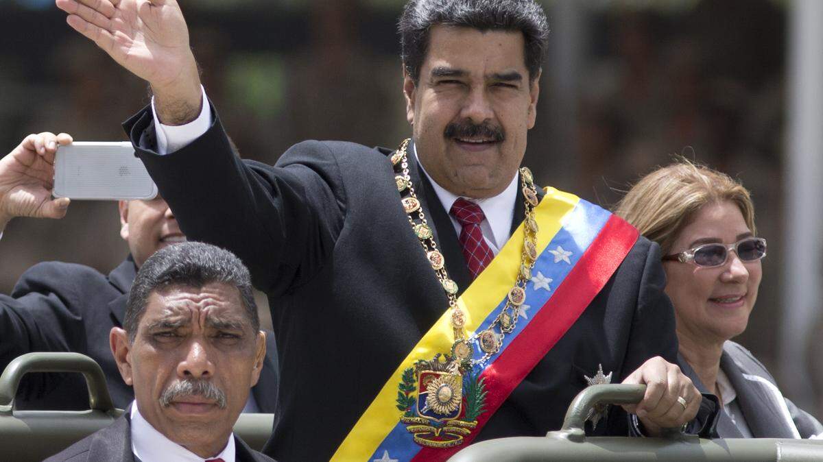 El gobernante venezolano Nicolás Maduro saluda junto a su esposa Cilia Flores en un desfile militar el 5 de julio por el Día de la Independencia..
