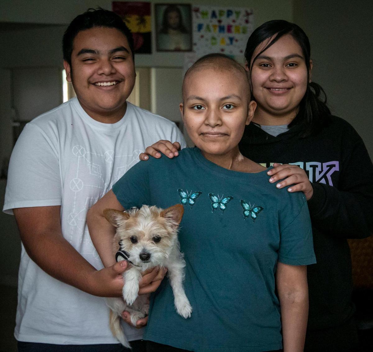 Sofía Macario, cargando a su perrito Caramelo, una gran ayuda durante el proceso de curación de la leucemia, junto a sus hermanos Kevin y Lizette en su casa de Coral Springs, el 19 de noviembre. Macario es una de las nominadas para recibir la ayuda del Wish Book, un proyecto anual del Miami Herald y el Nuevo Herald que solicita la ayuda de la comunidad.