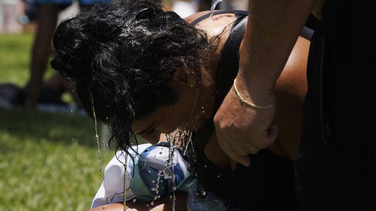 La familia Bonutti, originaria de Argentina, se echa agua encima durante una reunión para ver el partido entre Argentina y Egipto de la Copa Mundial de la FIFA —celebrado el martes 7 de julio de 2026 en el parque Lummus de Miami Beach— mientras está vigente un aviso de calor.