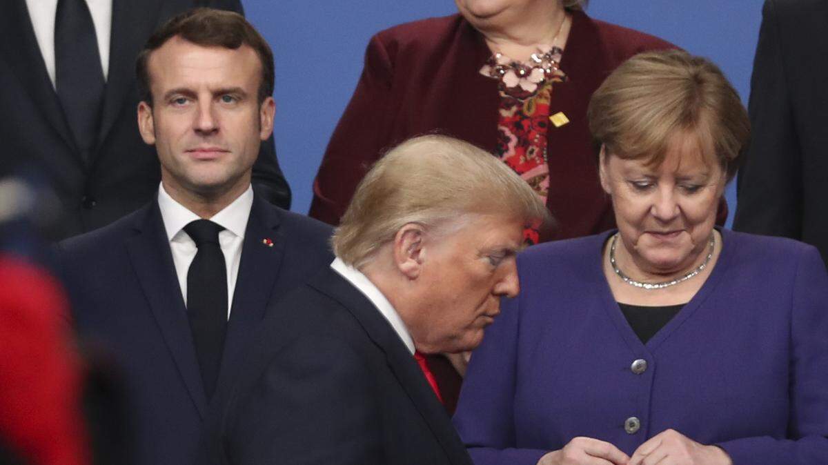 El presidente de Estados Unidos, Donald Trump (centro) camina frente a su homólogo francés Emmanuel Macron (izq.) y la canciller de Alemania, Angela Merkel (der.), para posar para la foto oficial de la Cumbre de la OTAN, el miércoles 4 de diciembre de 2019, en Watford, Inglaterra.