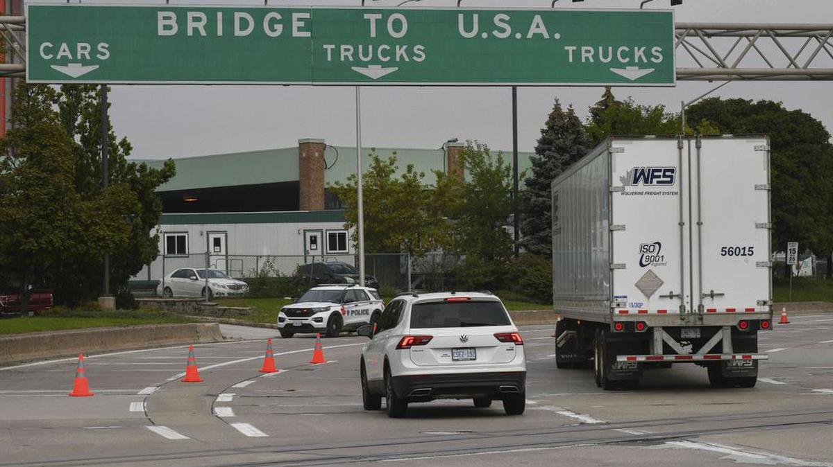 En esta fotografía de archivo del 4 de octubre de 2021, el tráfico se dirige hacia un vehículo de la policía junto al cruce fronterizo Ambassador Bridge en Windsor, Ontario, Canadá. Rob Gurdebeke / The Canadian Press vía AP, archivo)