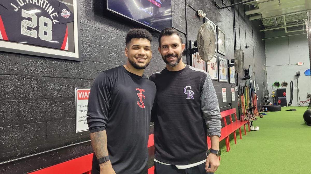 Víctor Mesa Jr. junto al profesor Ricardo Sosa tras una jornada de entrenamiento de bateo.