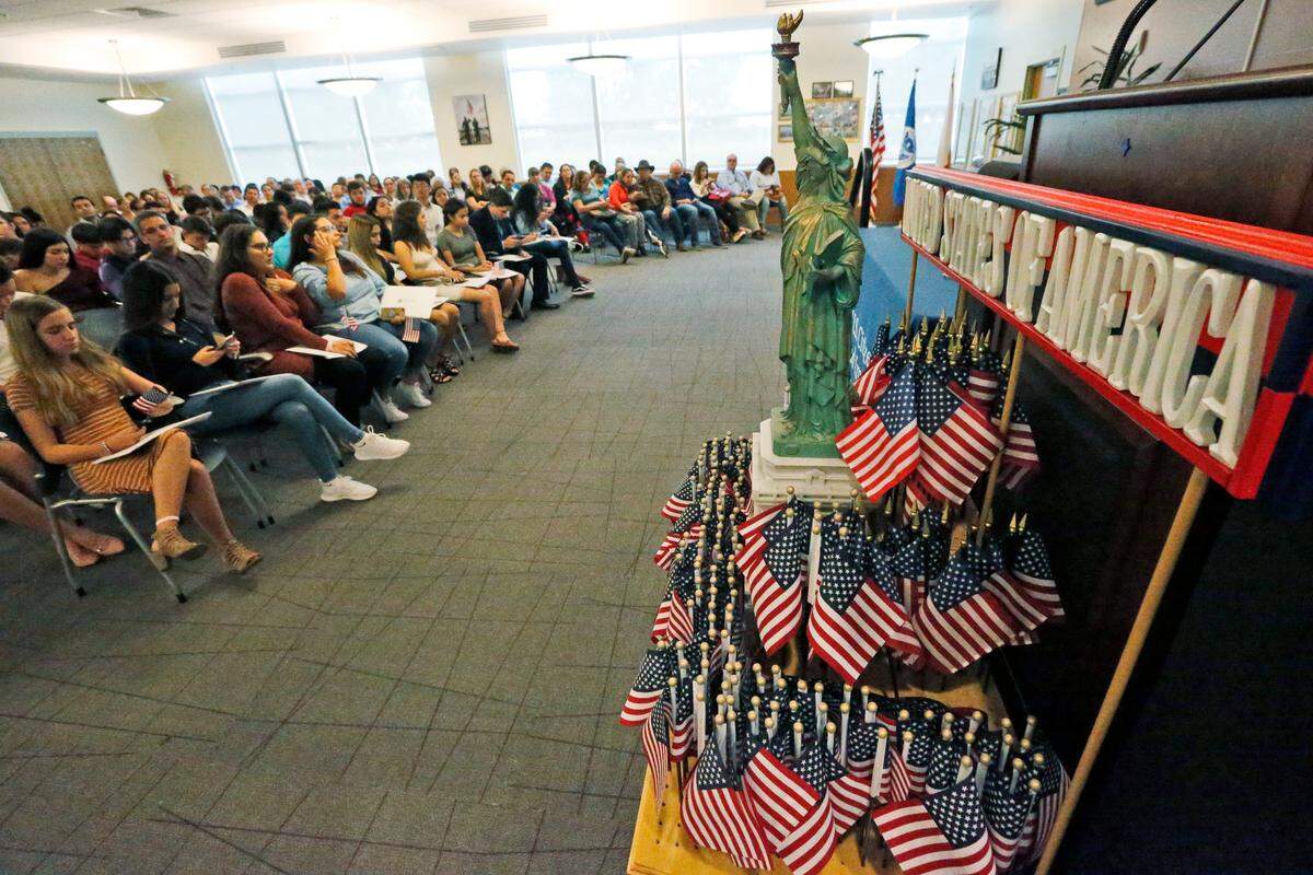 USCIS ha actualizado su Centro de Recursos de Ciudadanía: Hay muchos recursos gratuitos para todos, incluso estudiantes, profesores y organizaciones de ciudadanía. En la imagen, banderines de Estados Unidos y una representación en miniatura de la Estatua de la Libertad decoran la sala del recinto de USCIS en Kendall, donde el 30 de agosto de 2018 se realizó una ceremonia de naturalización.