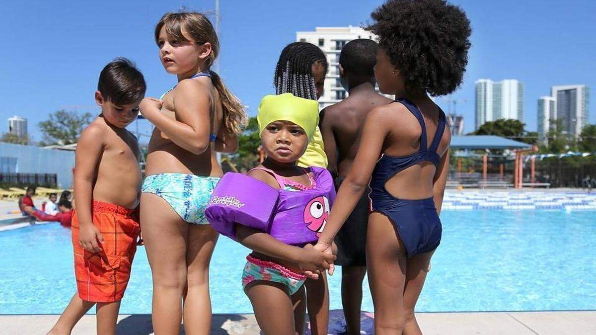Cari Mobley, de 3 años, Ymani Elong, y otros niños esperan para entrar en la piscina el miércoles, 3 de mayo de 2017, durante el programa de natación de verano en Gibson Park. CARL JUSTE cjuste@miamiherald.com 