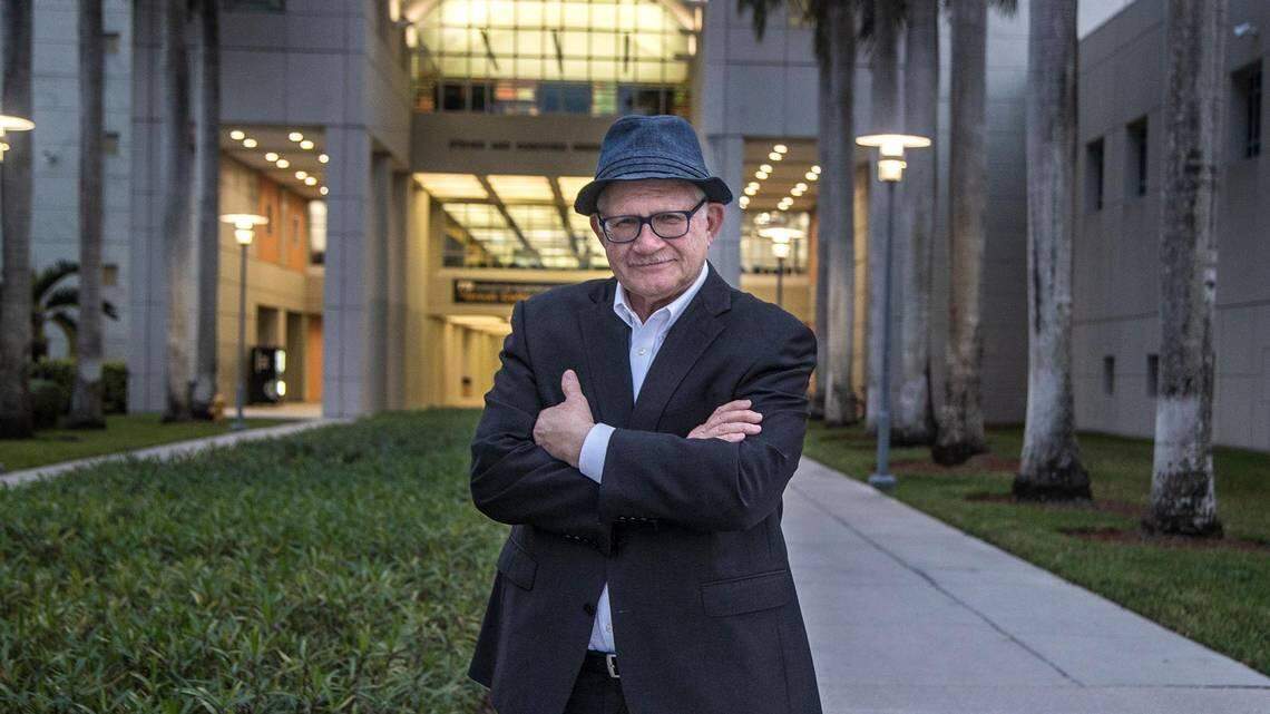 Mark Rosenberg, who resigned as president of Florida International University in January 2022, stands in front of the Steven and Dorothea Green Library at FIU’s Modesto Maidique campus in southwest Miami-Dade on Dec. 14, 2021. He will return in January to teach one class per semester.